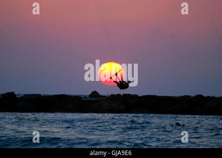 Le kite surf saut dans la mer Méditerranée l'internaute passe le soleil au coucher du soleil Banque D'Images