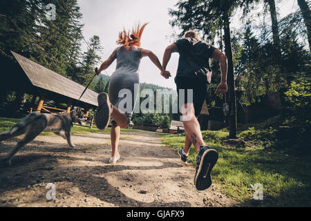 Couple fonctionne sur route dans la nature avec un chien Banque D'Images