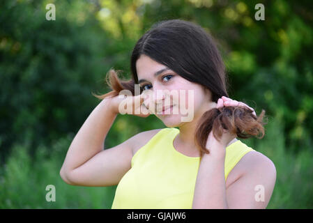 Girl détient ses mains sur la nature de cheveux Banque D'Images