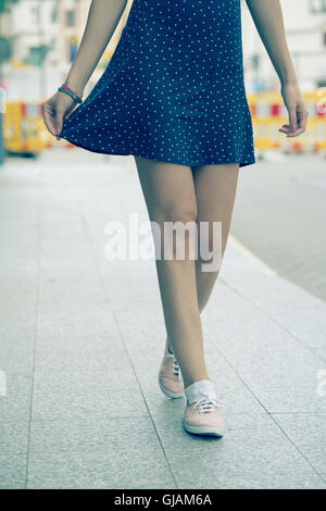 Les jambes de fille vêtue d'une robe courte, et des chaussures. Photo couleur Banque D'Images