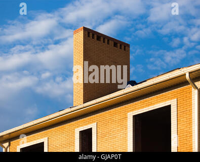 Sous le toit de tuiles avec beaucoup de constructions et cheminée en brique jaune Banque D'Images