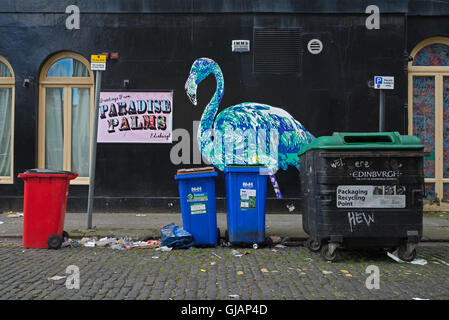 Poubelles et d'ordures dans la rue sur le côté de la Paradise Palms de noms de lieu d'exposition à Édimbourg. Banque D'Images