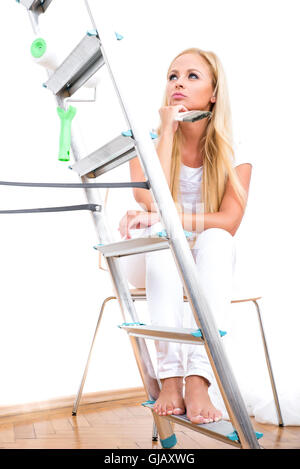 Une belle jeune femme blonde avoir une pause de l'emplacement sur une chaise et la pensée Banque D'Images