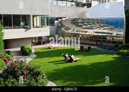 Zone de repos et de détente dans un hôtel moderne du centre-ville. Chaises longues et pelouse verte Banque D'Images