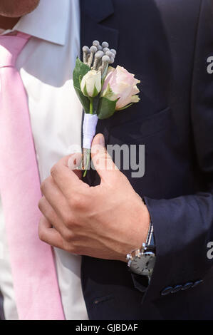 Le marié porte Boutonnière de roses sur sa veste avant la cérémonie de mariage Banque D'Images