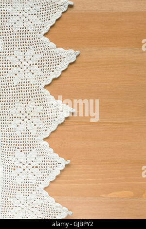 Vintage blanc original fait main frame dentelle crochetée. Étoffes sur table en bois. Banque D'Images