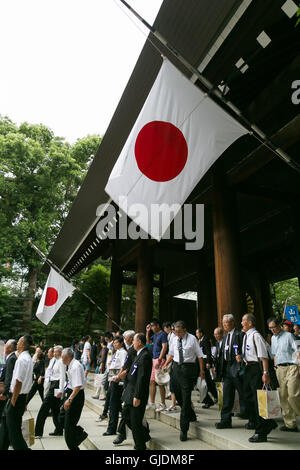 Tokyo, Japon. Août 15, 2016. Les gens marcher sous des drapeaux japonais en berne par respect pour les morts à la guerre à l'entrée du temple Yasukuni sur le 71e anniversaire de la capitulation du Japon dans la deuxième guerre mondiale, le 15 août 2016, Tokyo, Japon. Certains législateurs ont visité le sanctuaire 70 pour rendre un dernier hommage, mais le Premier ministre Shinzo Abe n'a pas visiter le symbole controversé et envoyé au lieu d'un rituel offrant à un temple. Credit : AFLO Co.,Ltd/Alamy Live News Banque D'Images