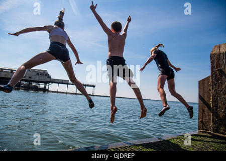 Pays de Galles Aberystwyth UK, lundi 15 août 2016 UK Weather : Les adolescents de leurs longues vacances d'été s'amusant de sauter dans la jetée en bord de mer clair frais à Aberystwyth, sur la côte ouest du pays de Galles. Le temps est réglé à améliorer au cours des deux jours, culminant en une mini-canicule le mercredi, avec des températures qui devraient atteindre la haute ou basse 20s 30s centigrades Crédit photo : Keith morris/Alamy Live News Banque D'Images