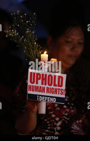 Quezon City, Philippines. Août 15, 2016. Un militant est titulaire d'une bougie pour dénoncer les exécutions extra-judiciaires contre les suspects impliqués dans les drogues illicites au cours d'un meeting de protestation à Quezon City, Philippines, le 15 août 2016. Le volume de la criminalité a diminué de 9,8 pour cent sur un an en juillet, un mois après que le Président Rodrigo Duterte a pris le pouvoir, comme le dernier numéro de la drug suspects qui ont été tués a frappé 592, un haut fonctionnaire du gouvernement a déclaré dimanche. Credit : Rouelle Umali/Xinhua/Alamy Live News Banque D'Images