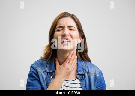 Femme frustrée dans la douleur avec un mal de gorge Banque D'Images