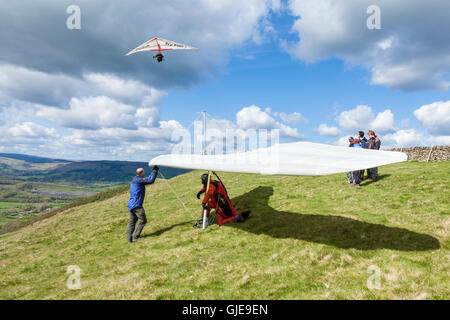 Deltaplane dans le Peak District. Un planeur prêt à décoller alors qu'un autre est volant au-dessus. Bord de Bradwell, Derbyshire, Angleterre, RU Banque D'Images
