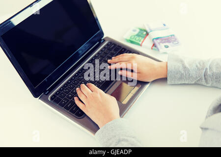 Close up of woman les mains avec de l'argent et l'ordinateur portable Banque D'Images