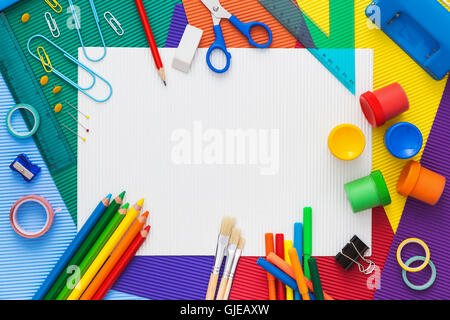 Composition multicolore de fournitures scolaires avec le papier blanc sur le centre. Retour à l'école. Mise à plat Banque D'Images