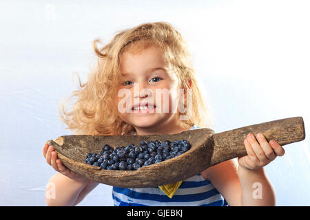 Petite fille tenant un seau de petits fruits bleuets Banque D'Images