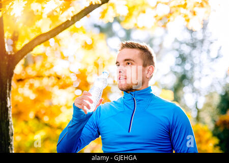 En automne nature Hipster runner de la bouteille de l'eau potable Banque D'Images