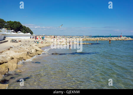 Excursionnistes et les vacanciers profiter du temps chaud et les eaux claires de la plage de Sandbanks sur la côte sud du Royaume-Uni. Banque D'Images