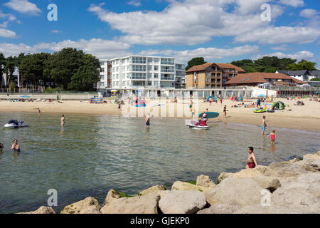 Excursionnistes et les vacanciers profiter du temps chaud et les eaux claires de la plage de Sandbanks sur la côte sud du Royaume-Uni. Banque D'Images