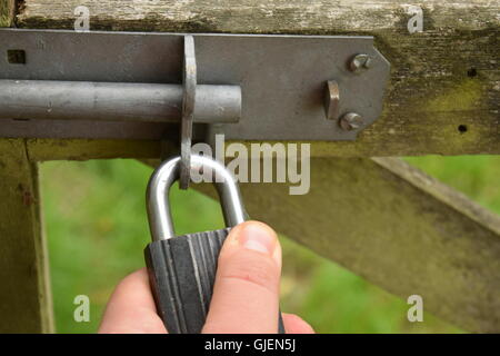 Homme tenant un cadenas sur une porte de Banque D'Images