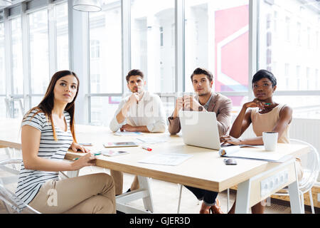 Des jeunes gens d'affaires rester assis et écouter à la conférence in office Banque D'Images