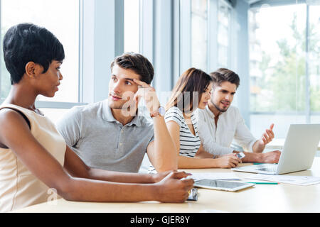 Groupe de jeunes gens d'affaires assis et talking in office Banque D'Images