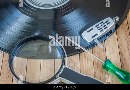 Disque vinyle avec une loupe,tournevis et enveloppe de tête Banque D'Images