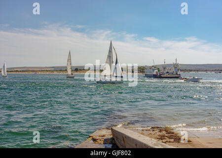 Excursionnistes et les vacanciers profiter du temps chaud et les eaux claires de la plage de Sandbanks sur la côte sud du Royaume-Uni. Banque D'Images