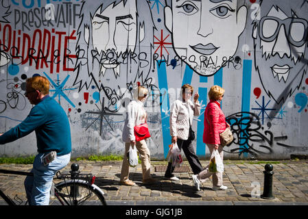 Les piétons passent devant un mur graffitied à Bruxelles, Belgique Banque D'Images