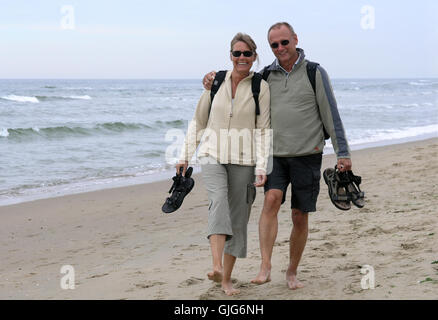 Couple d'âge moyen running on beach Banque D'Images