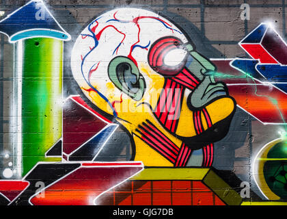 Les vapeurs chimiques respirable de la tête graffitis sont pulvérisées sur le reste d'un vieux mur, Friedrichshain, Berlin, Allemagne. Banque D'Images