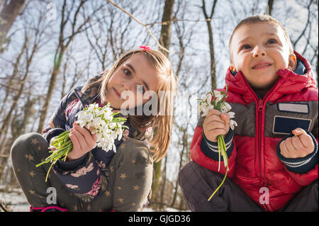 Garçon et fille la cueillette des fleurs de printemps Banque D'Images