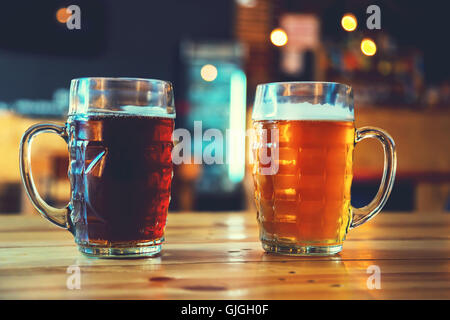 Gobelets lumière et obscurité bière sur une table de bois sur un fond de pub. assortiment de l'alcool dans un vol prêt pour la dégustation Banque D'Images