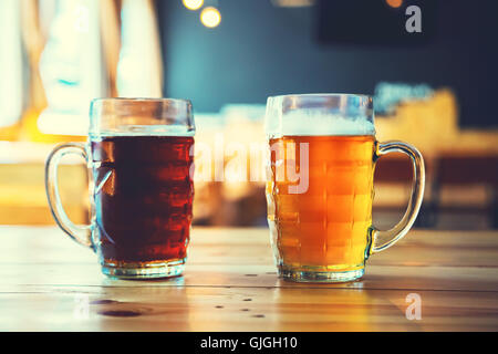 Gobelets lumière et obscurité bière sur une table de bois sur un fond de pub. assortiment de l'alcool dans un vol prêt pour la dégustation Banque D'Images