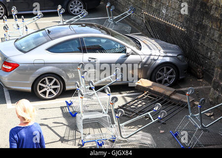 Bradford, West Yorkshire, Royaume-Uni. 16 août, 2016. vers l'heure du déjeuner aujourd'hui, le garde-corps perimiter du parking à Tesco dans Ilkley, West Yorkshire auraient été frappés par une voiture qui ne s'est pas arrêté à l'incident. le parapet en maçonnerie et est tombé sur une plaque de 12 mercedes c180 voiture dans le parking à Tesco laissant le propriétaire avec ce qui ressemblait à une radiation de l'assurance. l'trollies avait été placée pour empêcher les gens de trop près et des membres du personnel étaient fixant la limite dangereux qui avait une baisse d'environ 16 pieds de la sentier public pour le parking. crédit : Andrew Gardner/Alamy live news Banque D'Images