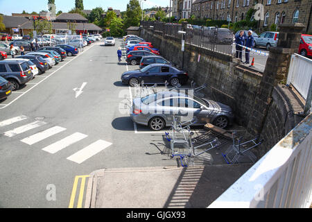 Bradford, West Yorkshire, Royaume-Uni. 16 août, 2016. vers l'heure du déjeuner aujourd'hui, le garde-corps perimiter du parking à Tesco dans Ilkley, West Yorkshire auraient été frappés par une voiture qui ne s'est pas arrêté à l'incident. le parapet en maçonnerie et est tombé sur une plaque de 12 mercedes c180 voiture dans le parking à Tesco laissant le propriétaire avec ce qui ressemblait à une radiation de l'assurance. l'trollies avait été placée pour empêcher les gens de trop près et des membres du personnel étaient fixant la limite dangereux qui avait une baisse d'environ 16 pieds de la sentier public pour le parking. crédit : Andrew Gardner/Alamy live news Banque D'Images