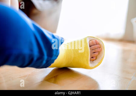 Jambe cassée dans la cast de méconnaissable petit garçon. Banque D'Images