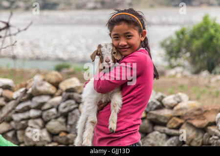 Le Népal, fille avec chèvre dans village de montagne. Banque D'Images