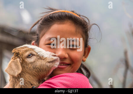 Le Népal, fille avec chèvre dans village de montagne. Banque D'Images