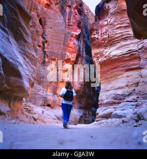 Le Siq, l'encoche étroite-canyon qui sert de couloir d'entrée à la ville cachée de Petra, Jordanie, vu ici avec tourist Banque D'Images