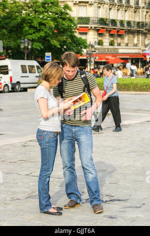 Les jeunes touristes regardant un guide à Paris, France. Banque D'Images