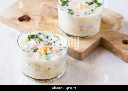 Soupe froide d'été traditionnel russe okroshka avec le kéfir dans les verres sur la table en bois blanc Banque D'Images