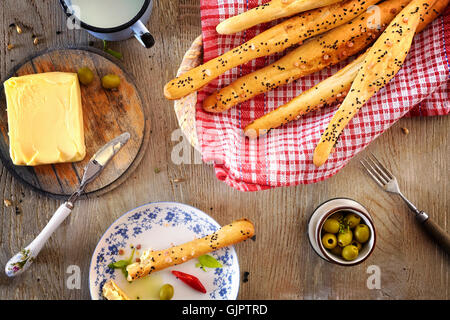 Bâtonnets de pain avec du beurre, le petit-déjeuner sur une table en bois. Banque D'Images