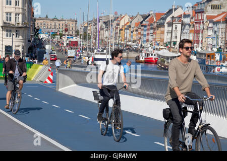 Les cyclistes ou cyclistes sur le nouveau pont pour piétons et cyclistes, Inderhavnsbroen Inner Harbour Bridge, reliant et Nyhavn, Copenhague Christianshavn. Banque D'Images