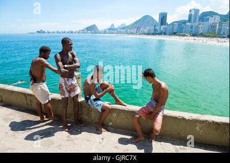 RIO DE JANEIRO - le 27 février 2016 : les jeunes Brésiliens se rassemblent pour plonger à partir de la corniche à Copacabana, à l'extrémité de la plage de Copacabana. Banque D'Images