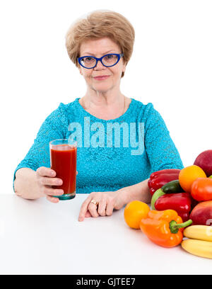 Femme joyeuse à l'âge des jus de tomate dans la main, isolé sur fond blanc Banque D'Images