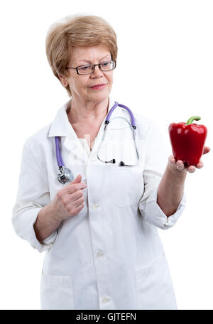 Un ancien médecin cardiologue regardant les poivrons rouges en forme de coeur, isolé sur fond blanc Banque D'Images