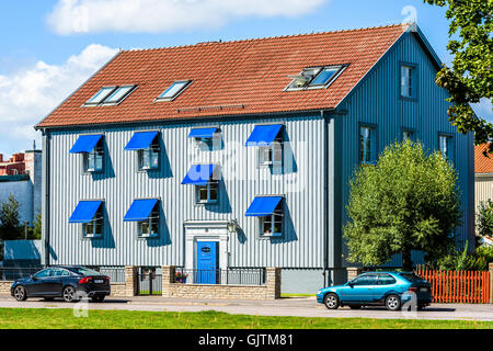 Kalmar, Suède - le 10 août 2016 : gris bleuté, chambre avec porte bleue et d'auvents. Deux voitures garées devant la maison. Banque D'Images