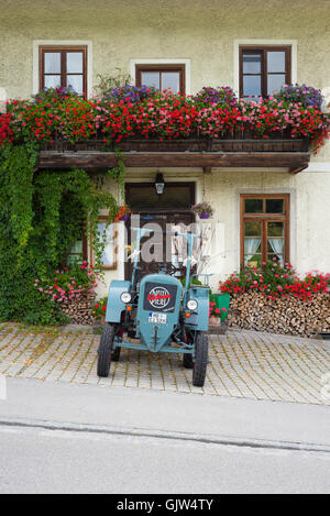 Diesel tracteur Eicher vintage garée en face de l'Lindl inn couverte de fleurs de géraniums, Bavière, Allemagne Banque D'Images