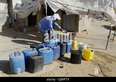 Hébron, en Cisjordanie, en territoire palestinien. Août 17, 2016. Un palestinien remplit les bouteilles en plastique et des bidons avec l'eau potable dans un réservoir d'eau dans le village cisjordanien de Um Alkhair au sud d'Hébron le 17 août 2016 Credit : Hashlamoun Wisam APA/Images/ZUMA/Alamy Fil Live News Banque D'Images