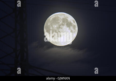 Hoenow, Allemagne. Août 17, 2016. La pleine lune sur la photo derrière un pylône dans un champ en Hoenow, Allemagne, 17 août 2016. PHOTO : PAUL ZINKEN/DPA/Alamy Live News Banque D'Images