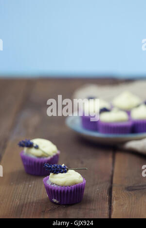 Mini lavande cupcakes avec glaçage au mascarpone sur table en bois. Gros plan avec une faible profondeur de champ et d'un grand espace de copie. Banque D'Images